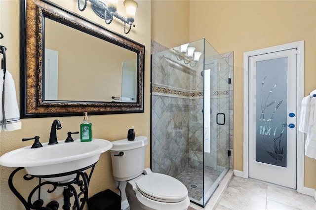 bathroom with an enclosed shower, sink, tile patterned floors, and toilet