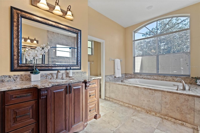 bathroom with tiled tub and vanity