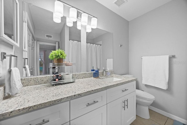 bathroom featuring toilet, tile patterned flooring, and vanity