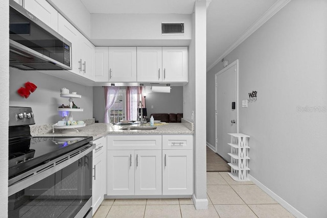 kitchen featuring light tile patterned floors, white cabinetry, appliances with stainless steel finishes, ornamental molding, and sink