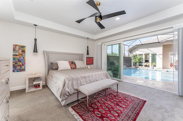 bedroom with ceiling fan, access to outside, light carpet, and a tray ceiling