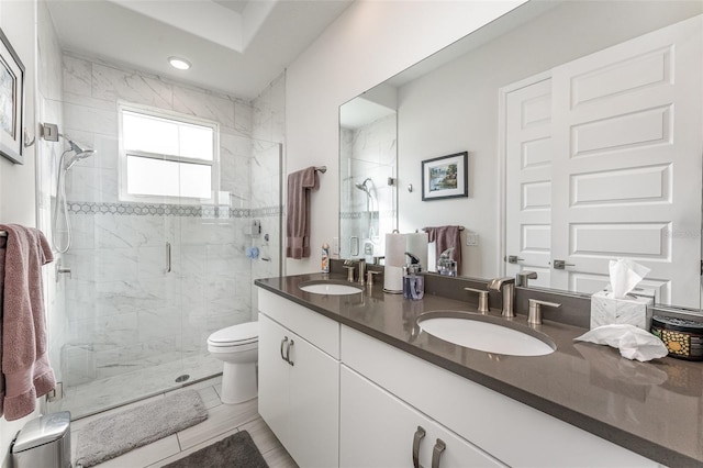 bathroom featuring vanity, toilet, and a shower with door