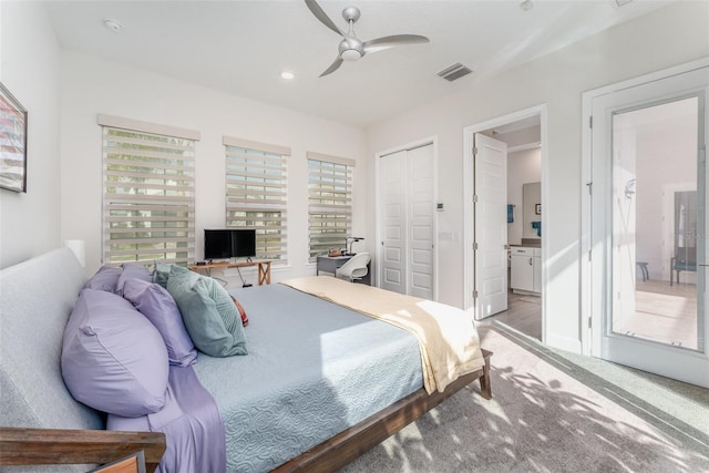 bedroom featuring ceiling fan, multiple windows, a closet, and ensuite bath