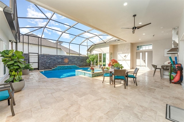 view of pool with glass enclosure, a patio area, a jacuzzi, and ceiling fan