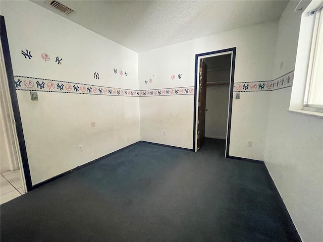 unfurnished room featuring a textured ceiling