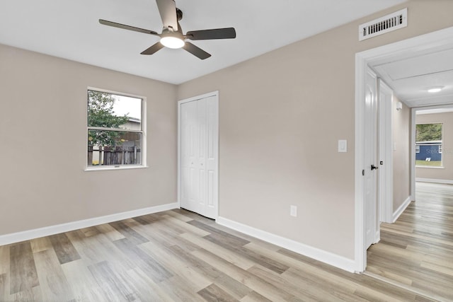 unfurnished bedroom featuring light wood-type flooring, ceiling fan, and a closet