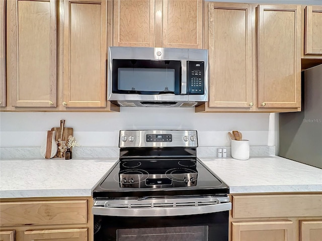 kitchen with light brown cabinetry and appliances with stainless steel finishes