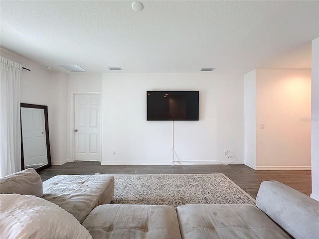 living room with a textured ceiling and dark hardwood / wood-style floors