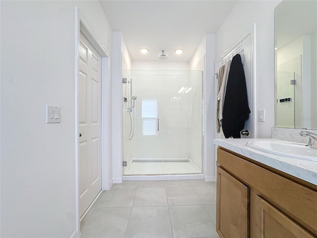 bathroom with walk in shower, vanity, and tile patterned floors