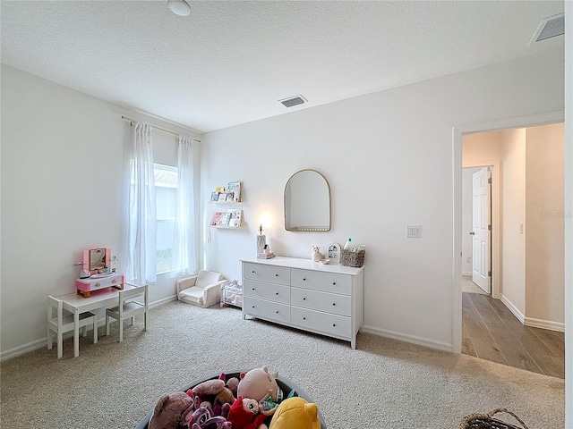 game room with light carpet and a textured ceiling