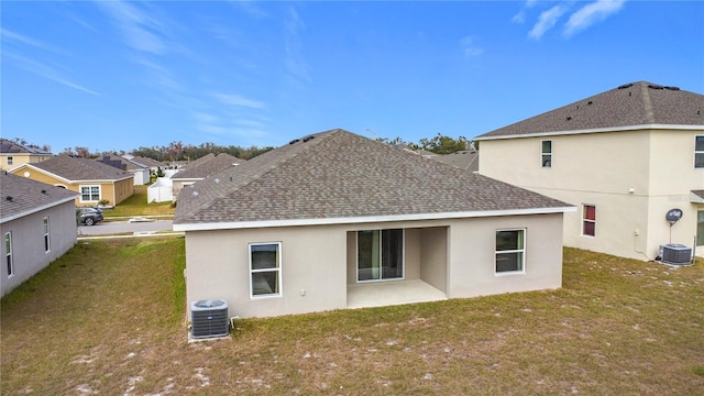 back of property featuring a lawn and central AC