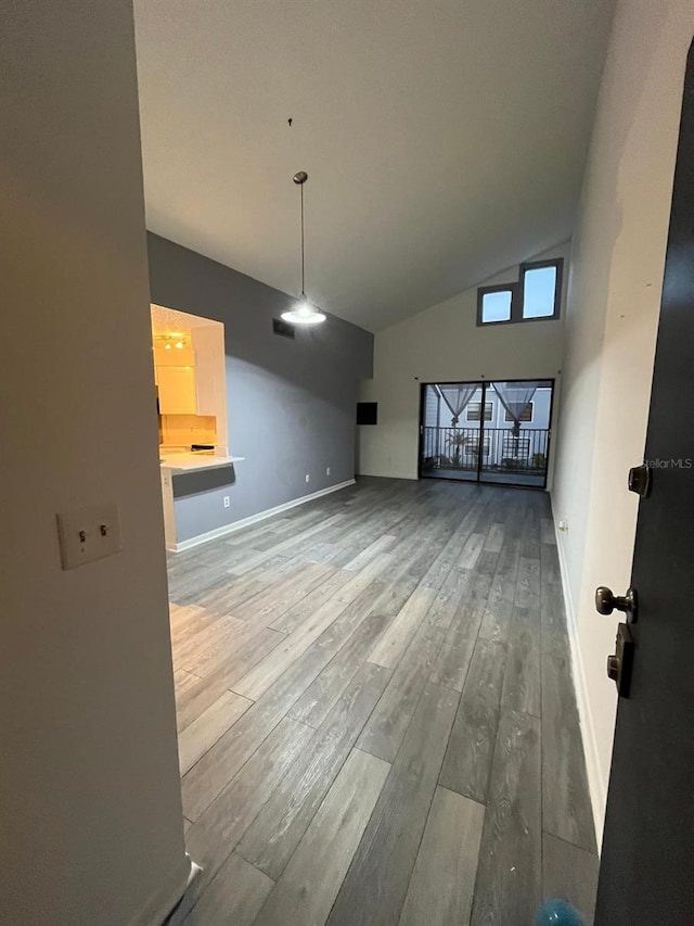 unfurnished living room featuring high vaulted ceiling and hardwood / wood-style floors