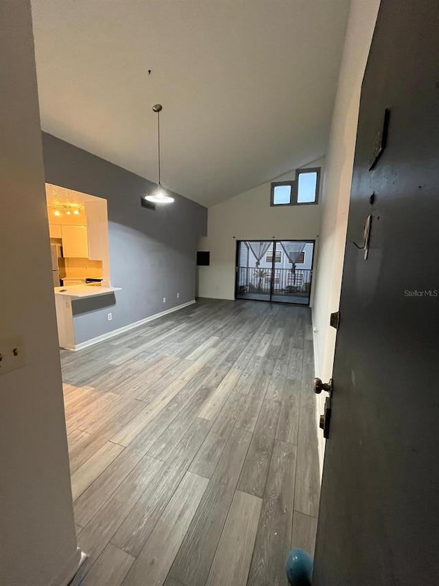 unfurnished living room with high vaulted ceiling and hardwood / wood-style floors