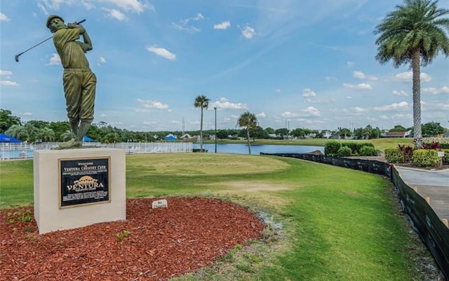 view of home's community with a water view and a lawn