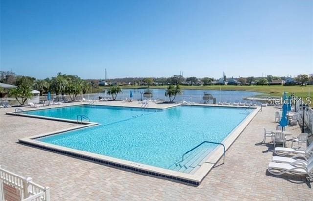 view of pool featuring a patio area and a water view