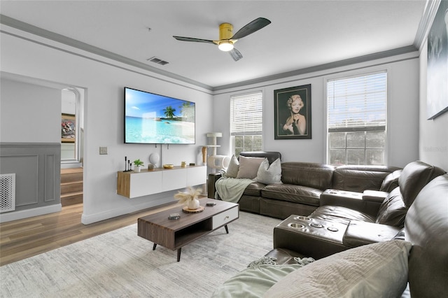 living room featuring ceiling fan, hardwood / wood-style flooring, and crown molding