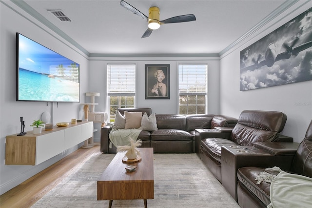 living room featuring ceiling fan, light hardwood / wood-style floors, and crown molding