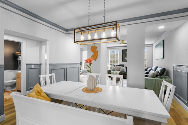 dining space featuring hardwood / wood-style flooring, a chandelier, and ornamental molding