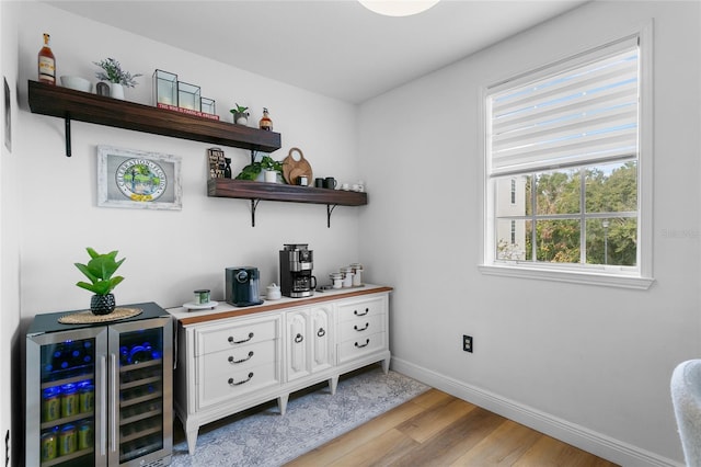 bar featuring white cabinets, light hardwood / wood-style floors, and beverage cooler