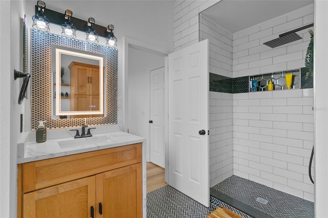 bathroom featuring tiled shower, tasteful backsplash, and vanity