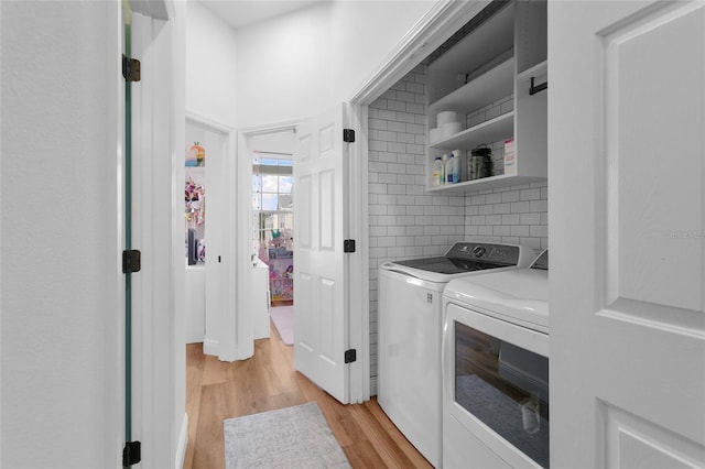 washroom featuring washer and clothes dryer and light hardwood / wood-style flooring