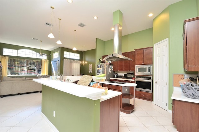 kitchen featuring decorative light fixtures, stainless steel appliances, an island with sink, sink, and island range hood