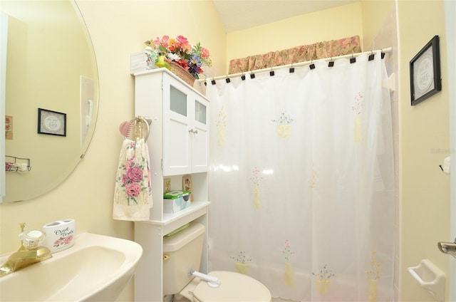 bathroom featuring sink, toilet, and walk in shower