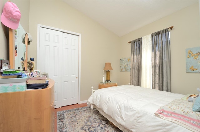 bedroom with hardwood / wood-style flooring, a closet, and vaulted ceiling