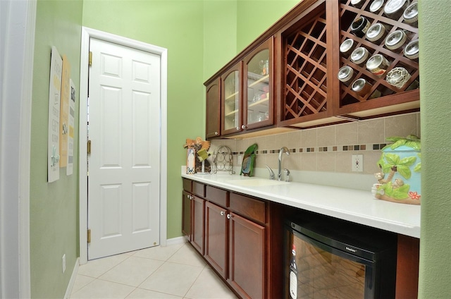 bar featuring tasteful backsplash, sink, beverage cooler, and light tile patterned flooring