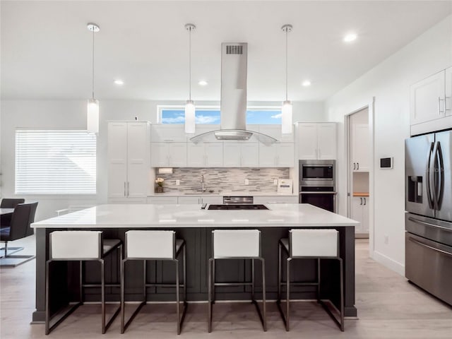 kitchen with white cabinets, island range hood, stainless steel appliances, and a large island