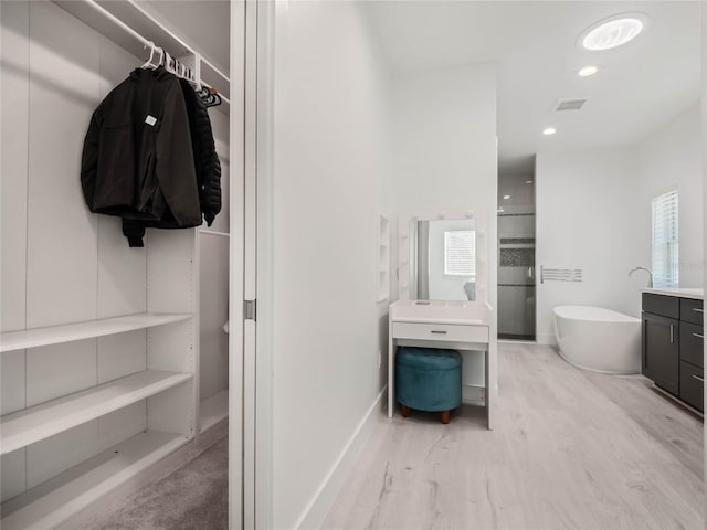 bathroom with a tub to relax in, hardwood / wood-style flooring, and vanity