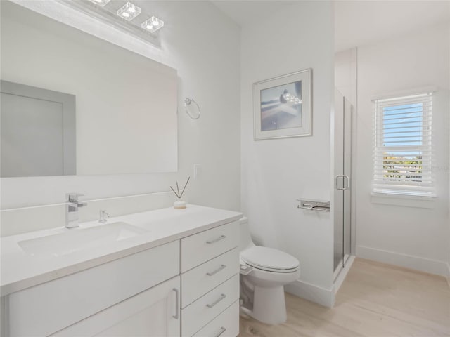 bathroom featuring toilet, hardwood / wood-style floors, an enclosed shower, and vanity