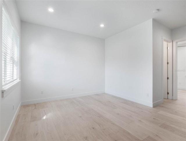 spare room with light wood-type flooring and plenty of natural light