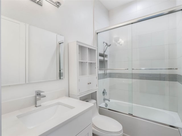 full bathroom with toilet, bath / shower combo with glass door, and vanity