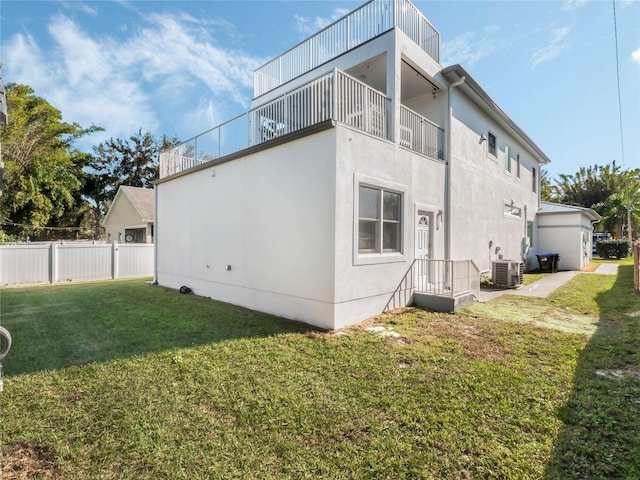 view of home's exterior with central AC unit, a balcony, and a yard