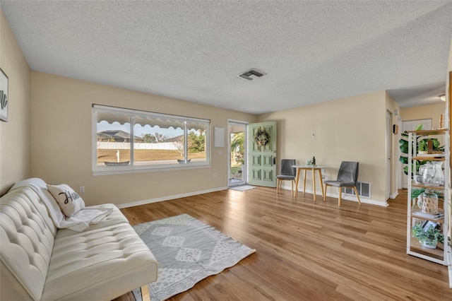 living area with light hardwood / wood-style flooring and a textured ceiling