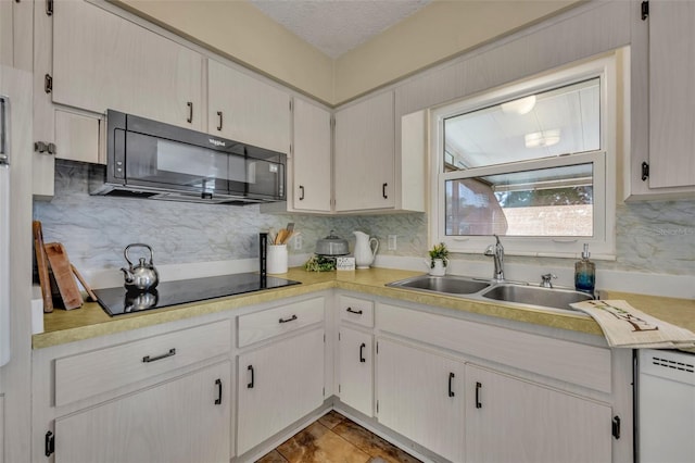 kitchen featuring sink, decorative backsplash, a textured ceiling, and black appliances