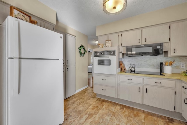 kitchen featuring backsplash, black appliances, and a textured ceiling