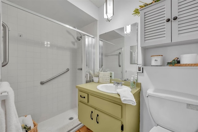 bathroom with a shower with door, vanity, and toilet