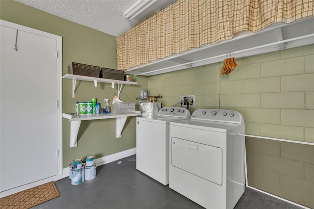 laundry room featuring separate washer and dryer and a textured ceiling