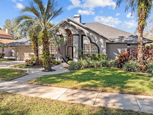 view of front facade with a front lawn and a garage