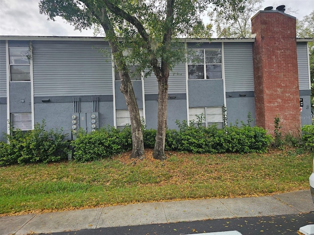 view of property exterior with a chimney and stucco siding