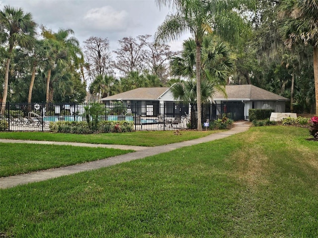 view of community with a lawn, fence, and a pool