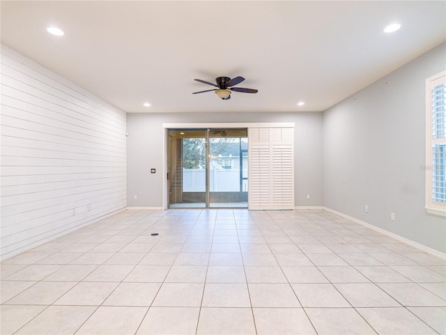 empty room featuring ceiling fan, a healthy amount of sunlight, and light tile patterned floors