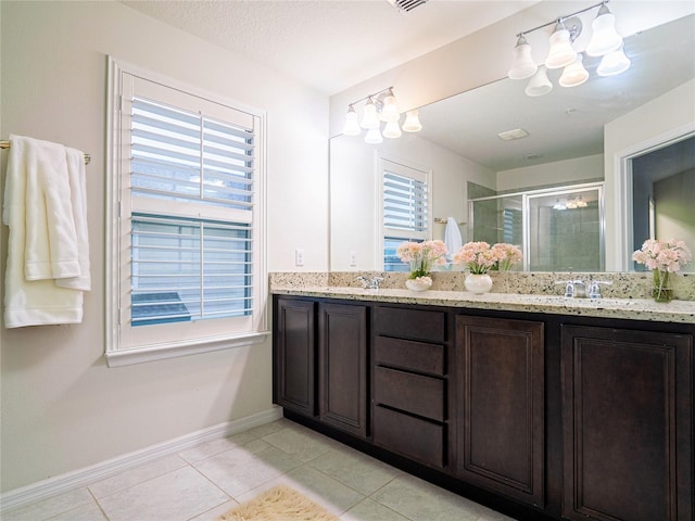 bathroom featuring a shower with shower door, plenty of natural light, vanity, and tile patterned flooring