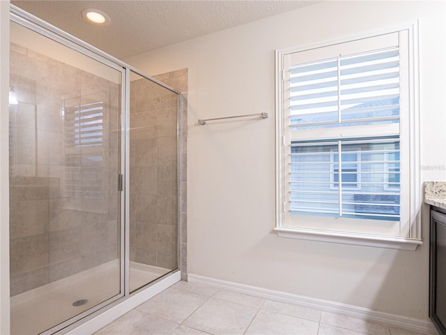 bathroom featuring tile patterned floors, a shower with door, and vanity