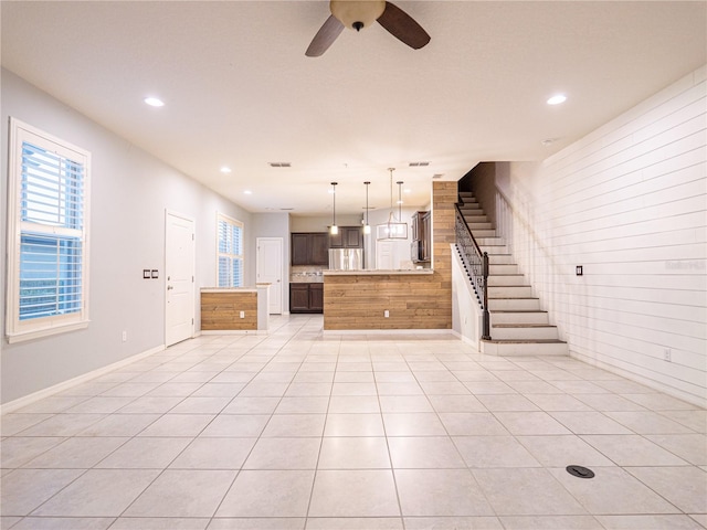 unfurnished living room featuring light tile patterned flooring and ceiling fan