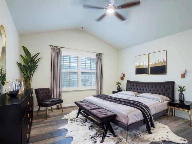 bedroom with vaulted ceiling, ceiling fan, and dark hardwood / wood-style flooring