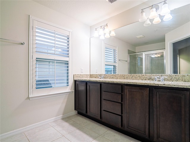 bathroom featuring vanity, a shower with door, and tile patterned flooring