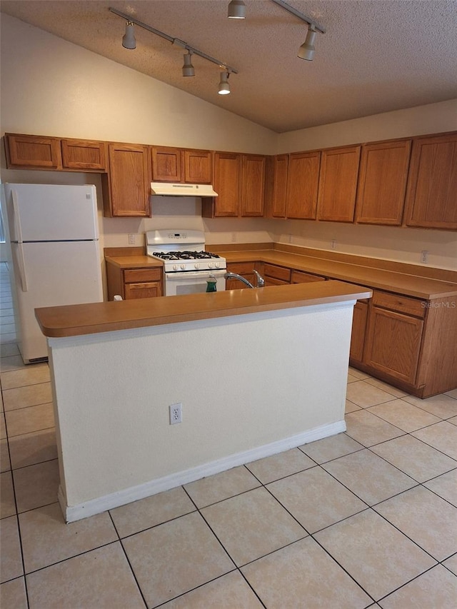 kitchen with white appliances, a center island with sink, light tile patterned floors, and a textured ceiling